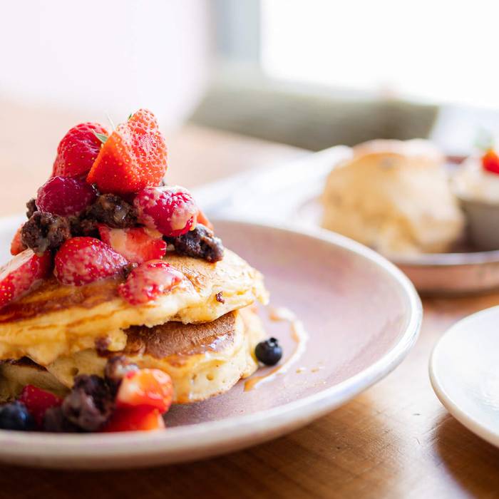 Pancakes with berries, a scone and a cappuccino