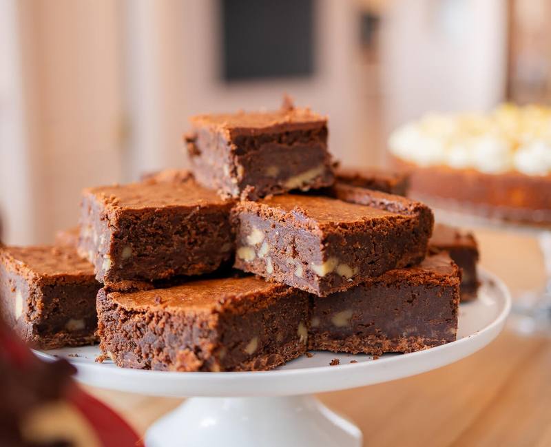 A stack of nut brownies on a cake stand
