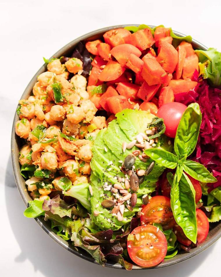 A bowl of chickpea, carrot, beetroot, avocado and leaf salad